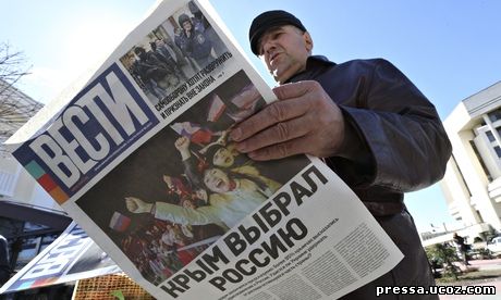 мужчина читает газеты о выборе Крыма